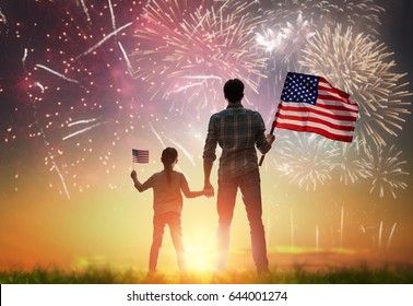 Patriotic holiday. Happy kid, cute little child girl and her father with American flag. USA celebrate 4th of July.