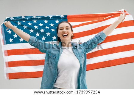Patriotic holiday. Happy young woman with American flag. USA celebrate 4th of July.