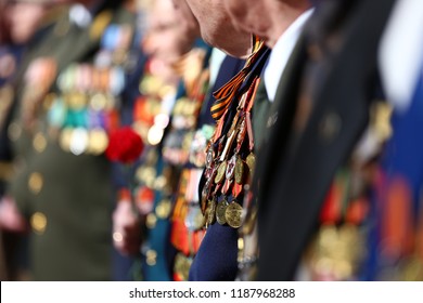 Patriotic holiday in honor of the anniversary of the end of the war, veterans are congratulated, the old soldiers with a lot of medals and orders are holding flowers, the memory of the dead
