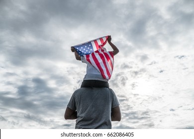 Patriotic holiday in USA,Father and son with American flag outdoors.USA celebrate 4th of July.Happy family independence day