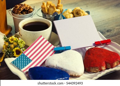 Patriotic party Concept -  Heart shaped cookies color red, blue, white. Cup of coffee (tea), USA flag, decoration on old wooden table. toned filter image. space for text - Powered by Shutterstock