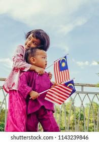 Patriotic Siblings Holding Malaysian Flag In Spirit Of Merdeka (Independence Day)