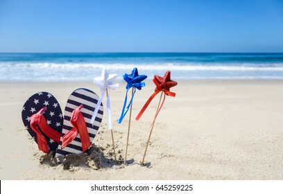 Patriotic USA Background With Flip Flops And Decorations On The Sandy Beach