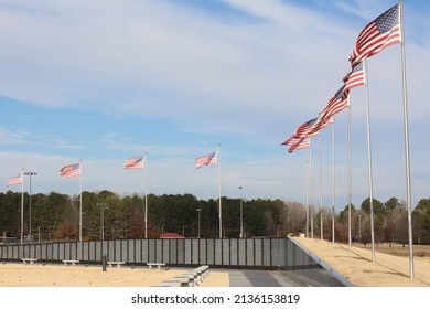 Patriotic Veterans Memorial Wall With Flags, Benches And A Blue Sky Background Located At Veterans Park In Tupelo, MS USA