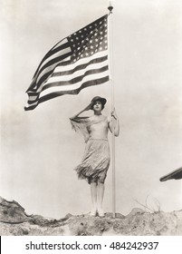 Patriotic Woman Holding American Flag And Saluting