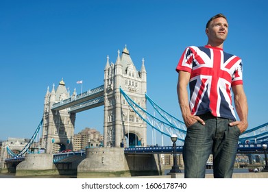 Patriotic Young British Man Standing In A Union Jack T-shirt In Front Of Tower Bridge London