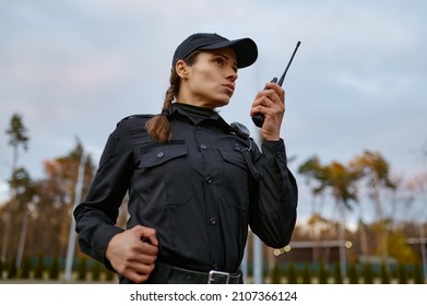 Patrol service police woman talking into walkie-talkie
