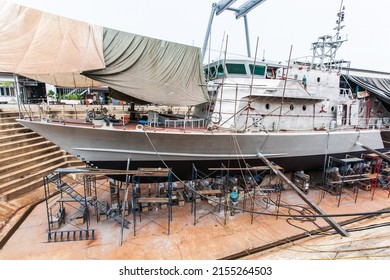 A Patrol Vessel Or Military Vessel Building In A Dry Dock At A Naval Shipyard.