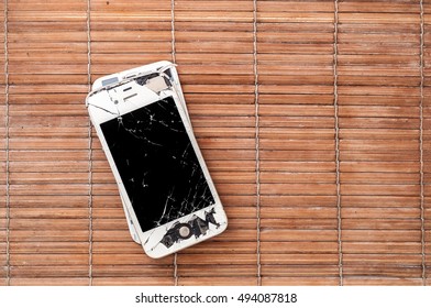 PATTAYA, THAILAND - 6 OCTOBER 2016: Studio shop of broken Smartphone of Apple Inc iPhone 4S on bamboo surface on 6 oct 2016 at Pattaya, Thailand.  Selective focus