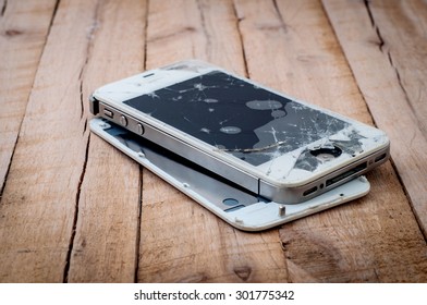 PATTAYA, THAILAND - JULY 31, 2015: Photo of a broken iPhone 4S on wooden surface on July 31,2015.