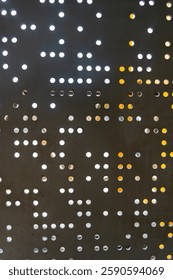 Pattern of black and white dots on a wall. The dots are arranged in a grid, with some larger and some smaller. The overall effect is a somewhat abstract and modern look