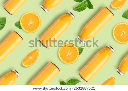 Pattern from bottles of orange juice and orange slices with leaves on green background, top view