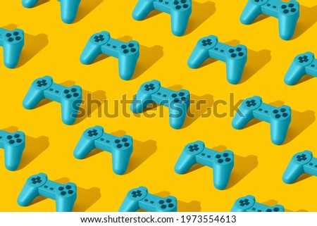 Pattern with bright blue retro game joypad controllers on yellow background. Minimal Flat lay concept. 3d render.
