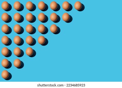 A pattern of brown chicken eggs lying diagonally on the upper left half of the blue background. Right side for copy space,  top view.















 

 





































 







 - Shutterstock ID 2234685923