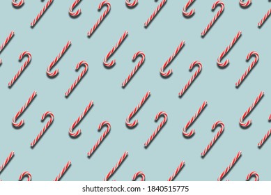 pattern candy canes on blue background, striped lollipop, Christmas composition, top view, flat lay, minimal concept