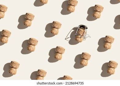 Pattern with champagne cork on beige background with hard light and shadow at sunlight. Trend layout with bottle cap from sparkling wine and metal wire muselet, repeat pattern top view, flat lay