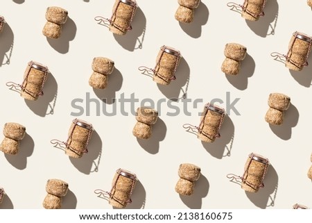 Pattern with champagne corks on beige background with hard light and shadow at sunlight. Summer wine drinks concept, bottle cap from sparkling wine and metal wire muselet, repeat pattern top view Foto stock © 