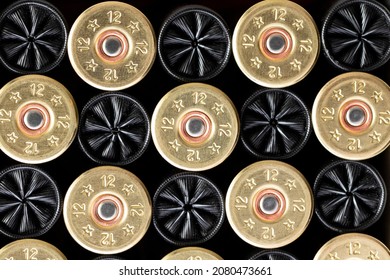 Pattern Of Collection Of Shiny Shotgun Cartridges For Hunting Placed In Rows On Black Background