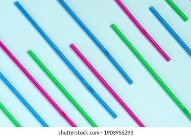 A pattern of colored beverage tubes laid out on a blue background - Shutterstock ID 1903955293