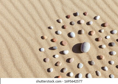 Pattern of colored pebbles in the shape of a circle on clean sand. The concept of serenity and meditation. Flat lay, Top view - Powered by Shutterstock