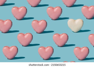 Pattern Created Of Pink Artisan Heart Shaped Pink French Patisserie And A White One. Pink Heart Shaped Yummy Irresistible Macaron Alone Against Baby Blue Background