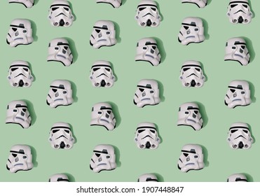 Pattern created of white Stormtrooper helmets from three positions – front, left and right sides. A top view with pastel green background. - Shutterstock ID 1907448847