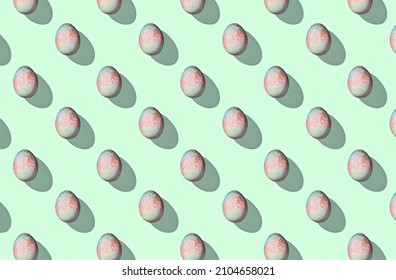 Pattern of easter eggs on green pastel background