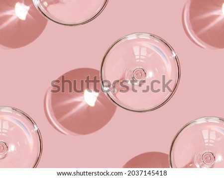 
pattern of empty glasses glass shadow pink background light through the glass