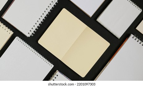Pattern from empty open notepads and notebooks on a black background