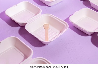 A pattern of empty packages with a wooden fork for bento cakes on a purple background. Selective focus.