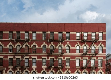 Pattern of fire escapes on side of older ornate brick building in New York City