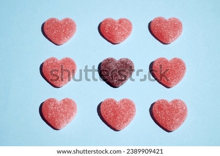 Pattern of gummy vitamin candy in shape of heart on blue background .Concept photography. High quality photo