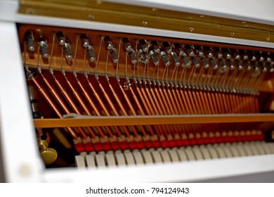 Pattern of hammers and strings inside piano, close up. One hummer in action while key is pressed. Stand out from the crowd concept.
