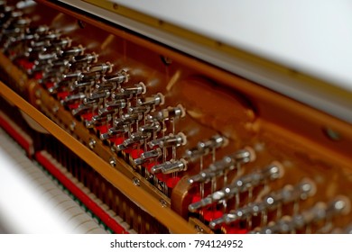 Pattern of hammers and strings inside piano, close up. One hummer in action while key is pressed. Stand out from the crowd concept.