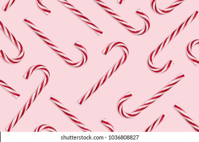 Pattern Of Hard Candy Cane Striped In Christmas Colors On Baby Pink Background. Red And White Striped Hard Candy Cane. Christmas Background. Candy Shop Concept.