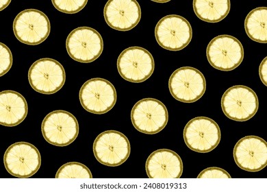 Pattern made of backlit lemon slices on black background
