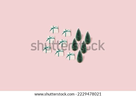 Pattern made with Christmas tree and  gift box on bright pastel pink background. Minimal creative New Year pattern. Present wrapped with green ribbon. Aesthetic Christmas holiday concept.