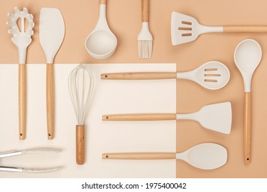 Pattern Made From Cooking Utensil Set. Silicone Kitchen Tools With Wooden Handle On Beige Background. Top View Flat Lay.