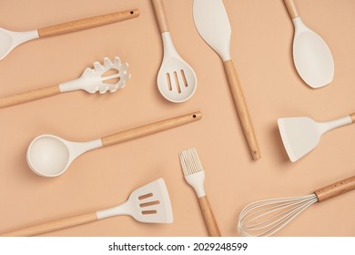 Pattern made from cooking utensil set. Silicone kitchen tools with wooden handle on beige background. Top view Flat lay. - Shutterstock ID 2029248599