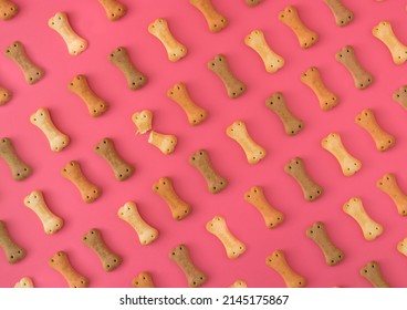 Pattern made of dog biscuits on pink background.