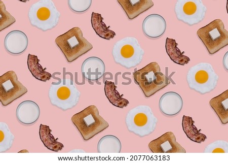 Pattern made with slices of crispy bacon, fried eggs, toast bread and glasses of milk on pastel pink background. Minimal and creative breakfast concept. Top view. Flat lay.