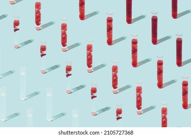 Pattern Made Of Various Test Tubes Containing Blood On A Light Blue Background. Bio Weapon Minimal Concept.