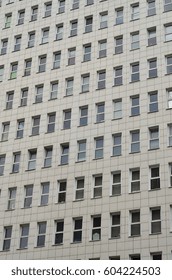 A pattern of many windows from a multi-storey office building. A large number of plastic windows in the wall of a modern multi-storey building
