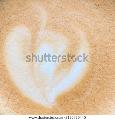 Pattern of milk on cappuccino foam close up. Warm background with selective focus. Flat lay style