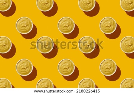 Pattern of mustard bowls on yellow pastel background