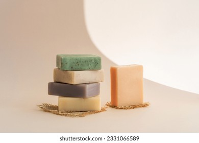 Pattern natural handmade soap of different sizes and colors. Brown background shadows of flowers from the sun. Cosmetic pedestal for product promotion