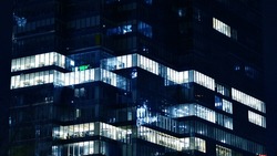 Pattern Of Office Buildings Windows Illuminated At Night. Glass Architecture ,corporate Building At Night - Business Concept. Blue Graphic Filter.