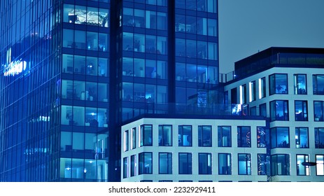 Pattern of office buildings windows illuminated at night. Glass architecture ,corporate building at night - business concept. Blue graphic filter. - Shutterstock ID 2232929411