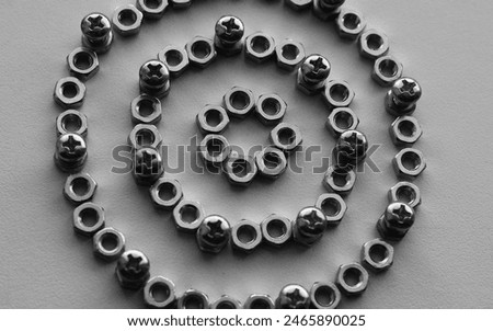 Pattern of perfect rings made of nuts with bolts screwed into them monochrome stock photo for mechanical backgrounds
