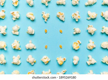 Pattern with popcorn flakes and unpopped corn aligned symmetrically on a seamless blue background. Pattern with popcorn and corn seeds, above view.